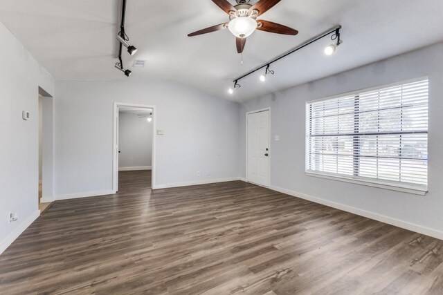 empty room with vaulted ceiling, ceiling fan, track lighting, and dark hardwood / wood-style floors