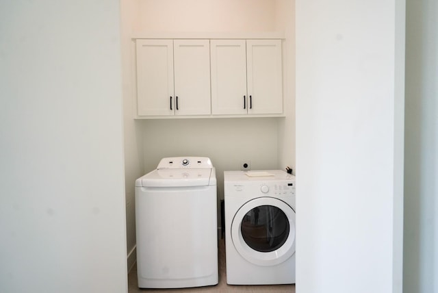 washroom featuring washing machine and dryer and cabinets