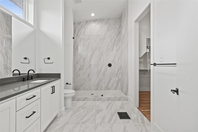 2120 Lovedale Ave Unit 101, Dallas, TX 75235 - bathroom featuring a tile shower, double vanity, marble look tiles, recessed lighting, and toilet