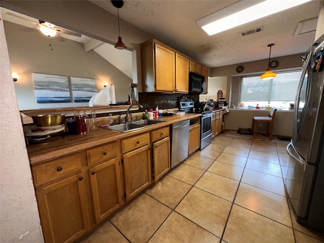 kitchen featuring ceiling fan, sink, decorative light fixtures, black appliances, and lofted ceiling with beams