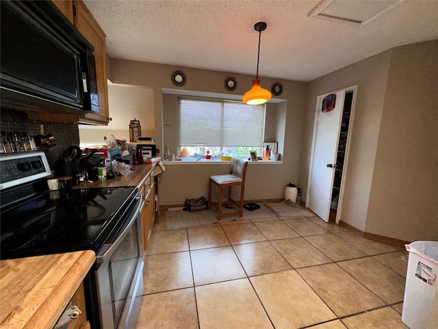 kitchen featuring backsplash, stainless steel electric range, a textured ceiling, light tile patterned floors, and pendant lighting