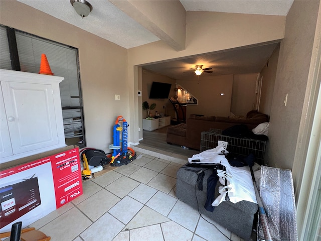 misc room with light tile patterned floors, vaulted ceiling with beams, and ceiling fan