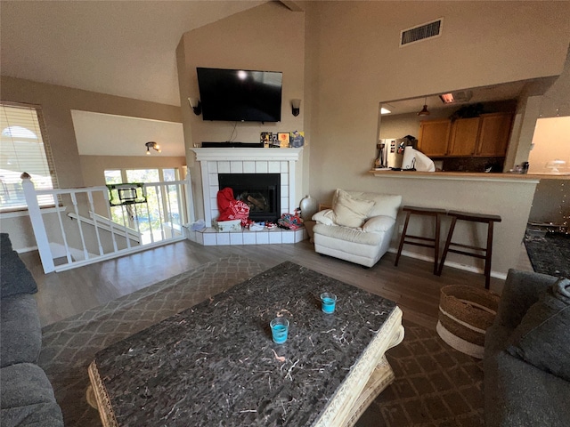 living room with dark hardwood / wood-style floors, a fireplace, and lofted ceiling