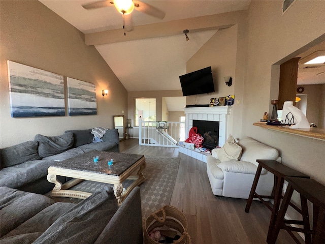 living room featuring ceiling fan, high vaulted ceiling, beam ceiling, hardwood / wood-style flooring, and a fireplace