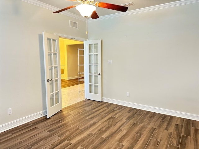unfurnished room featuring crown molding, visible vents, wood finished floors, and french doors