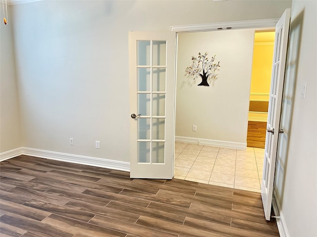 unfurnished room featuring baseboards, french doors, and dark wood-type flooring