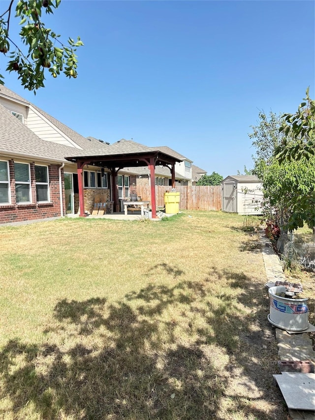 view of yard with an outdoor structure, a storage unit, a gazebo, fence, and a patio