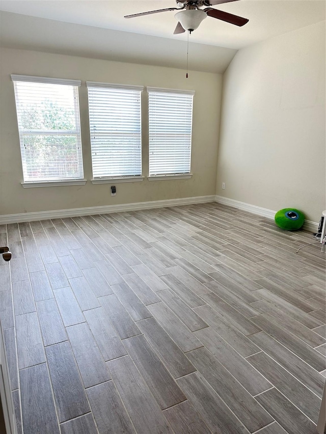 spare room featuring wood finished floors, ceiling fan, and baseboards