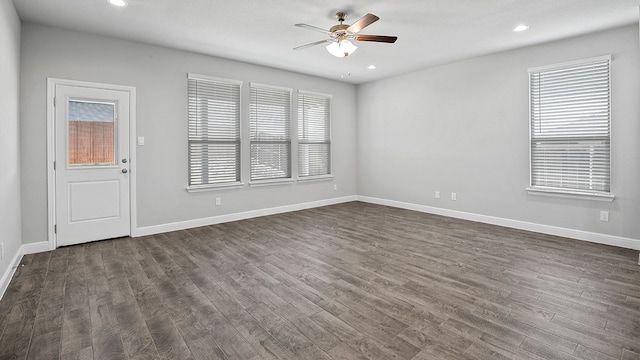 empty room featuring ceiling fan, hardwood / wood-style floors, and a healthy amount of sunlight