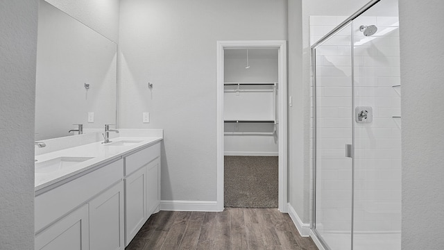 bathroom with an enclosed shower, hardwood / wood-style floors, and double sink vanity