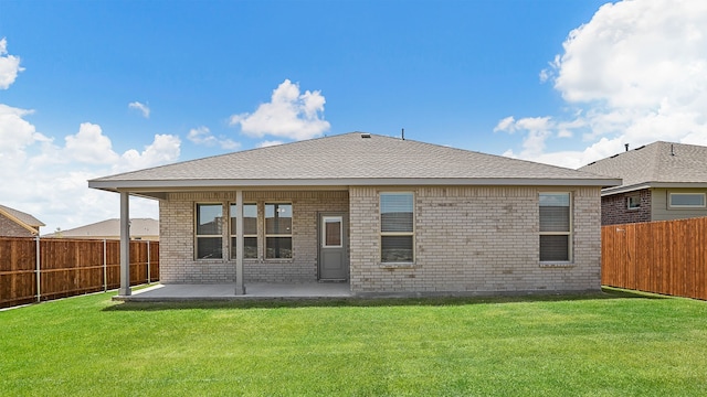 back of property with a patio and a yard