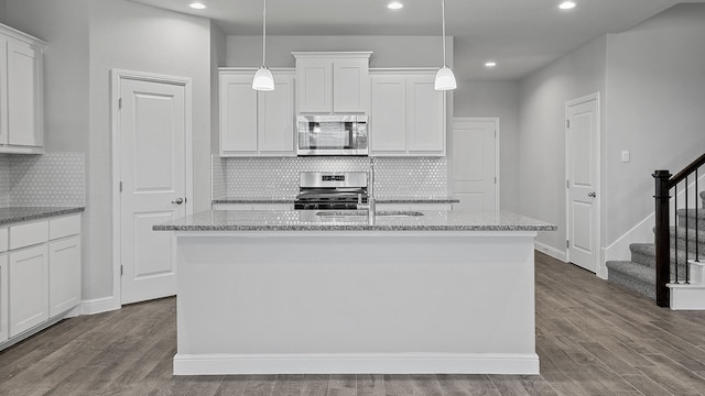 kitchen with decorative backsplash, stove, and white cabinets