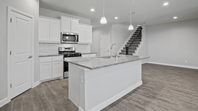 kitchen with light wood-type flooring, backsplash, light stone countertops, sink, and stainless steel appliances