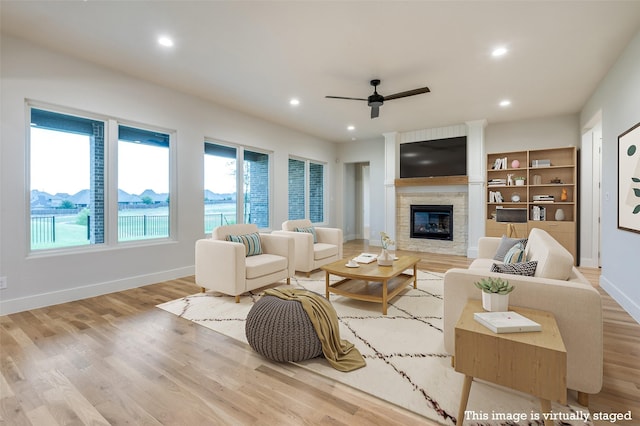 living room featuring a fireplace, plenty of natural light, and light hardwood / wood-style floors