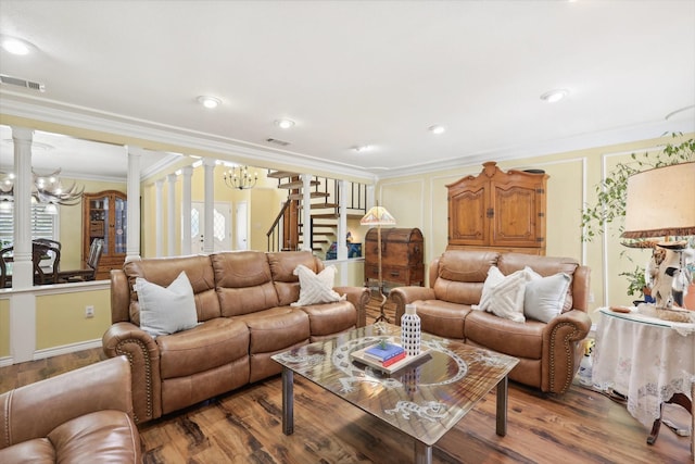 living room featuring a notable chandelier, ornamental molding, decorative columns, and wood-type flooring