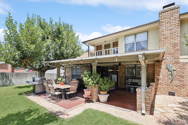 back of property featuring ceiling fan, a patio area, and a yard