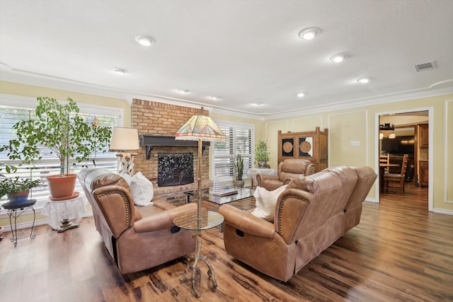 living room featuring a fireplace, ornamental molding, and hardwood / wood-style flooring