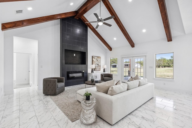 living room with high vaulted ceiling, french doors, ceiling fan, beam ceiling, and a tiled fireplace