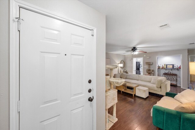 living room with dark hardwood / wood-style flooring and ceiling fan