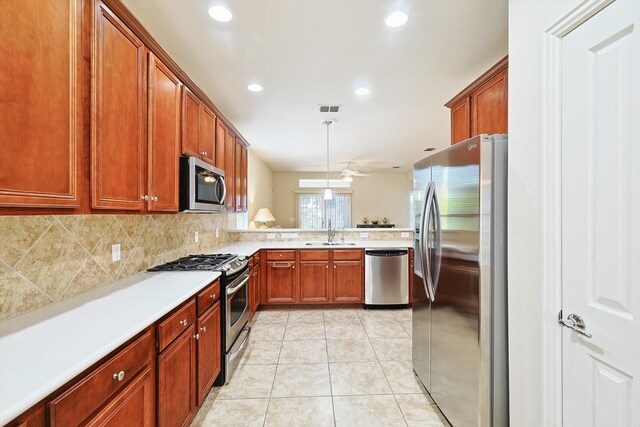 kitchen with ceiling fan, light tile patterned floors, sink, kitchen peninsula, and stainless steel appliances