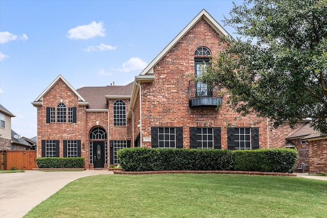 view of front of home featuring a front yard, fence, and brick siding