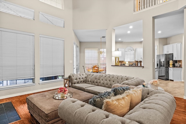 living room featuring plenty of natural light, hardwood / wood-style flooring, and a towering ceiling