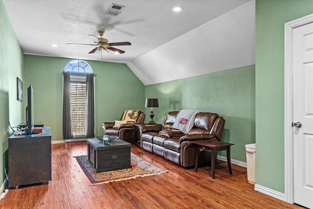 living room featuring ceiling fan, lofted ceiling, a textured ceiling, and wood-type flooring