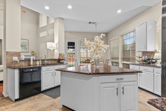 kitchen with kitchen peninsula, dishwasher, and white cabinetry