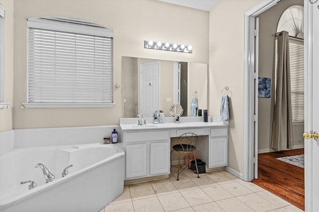 bathroom with a bath, tile patterned flooring, and vanity