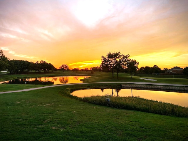 view of property's community featuring a lawn and a water view