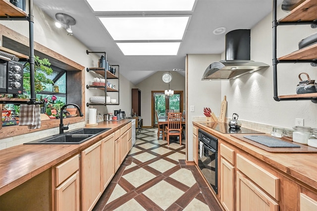 kitchen featuring sink, butcher block countertops, wall chimney exhaust hood, light tile patterned floors, and black appliances