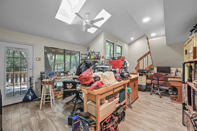 miscellaneous room with ceiling fan, vaulted ceiling with skylight, light hardwood / wood-style flooring, and a healthy amount of sunlight