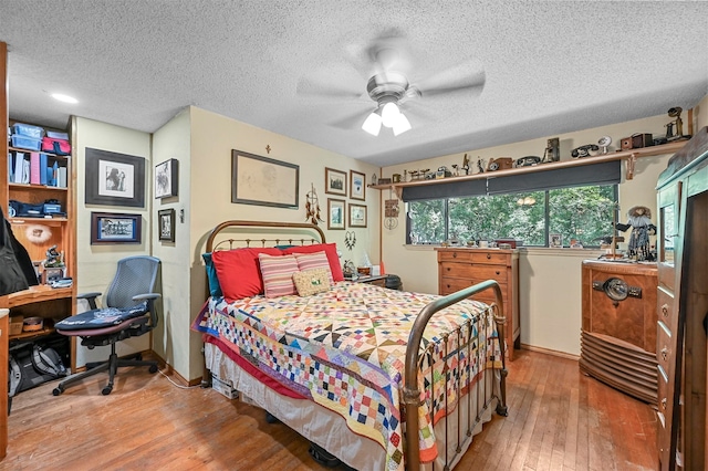 bedroom featuring ceiling fan, a textured ceiling, and hardwood / wood-style floors