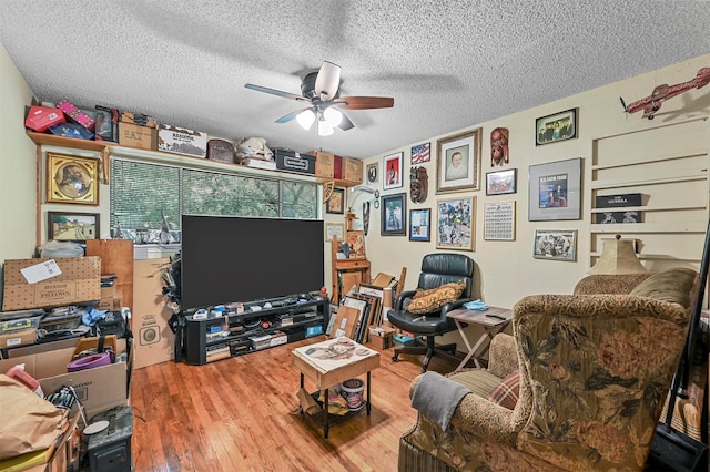 living room featuring a textured ceiling, ceiling fan, and hardwood / wood-style floors