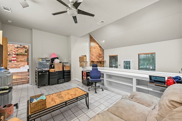 home office featuring ceiling fan, vaulted ceiling, light tile patterned flooring, and brick wall