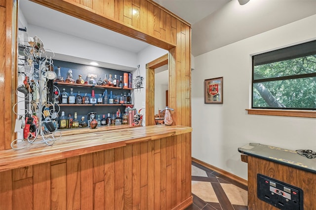 bar with wood counters and tile patterned flooring