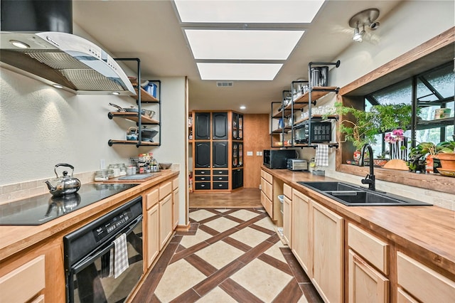 kitchen with butcher block countertops, light brown cabinetry, light tile patterned floors, sink, and black appliances