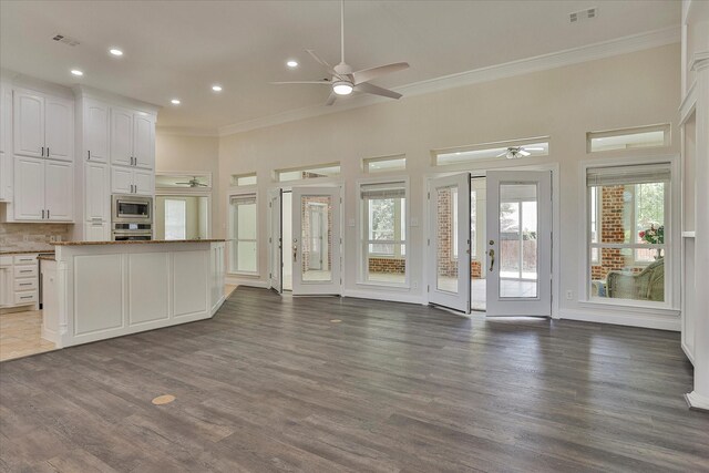 unfurnished living room with ceiling fan, crown molding, and dark hardwood / wood-style floors