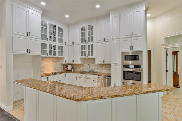 kitchen featuring backsplash, white cabinets, appliances with stainless steel finishes, sink, and stone counters