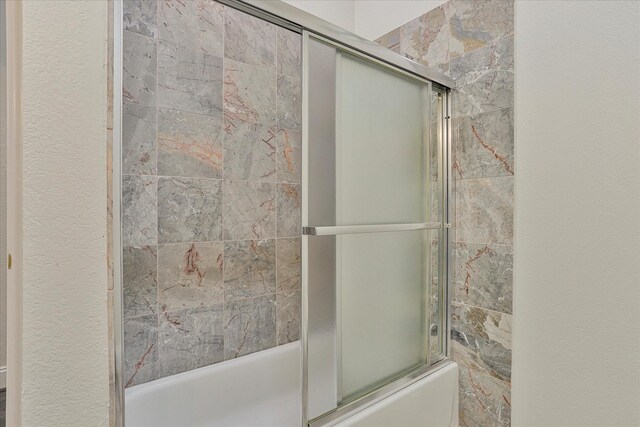 bathroom featuring shower / bath combination with glass door