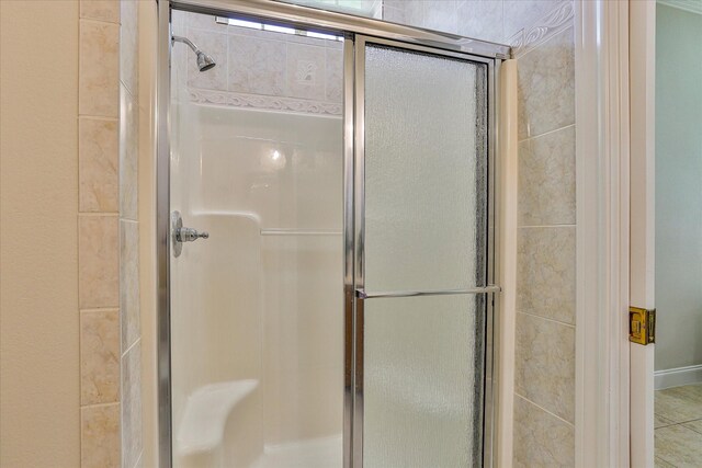 bathroom featuring a shower with shower door