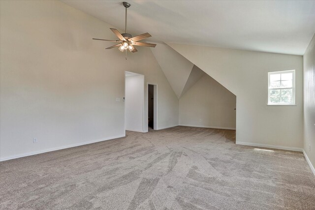 additional living space featuring ceiling fan, vaulted ceiling, and light carpet