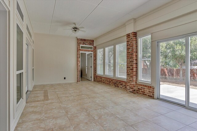 unfurnished sunroom with ceiling fan