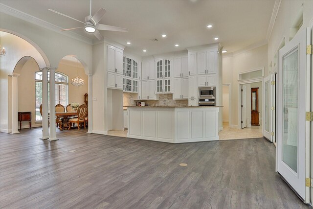 kitchen featuring decorative columns, light hardwood / wood-style flooring, white cabinetry, and stainless steel appliances