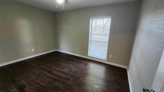 empty room featuring ceiling fan and dark hardwood / wood-style flooring