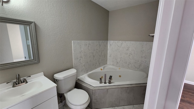 bathroom with hardwood / wood-style floors, tiled bath, toilet, and vanity