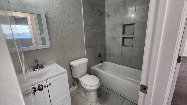 full bathroom featuring vanity, tiled shower / bath combo, hardwood / wood-style floors, and toilet