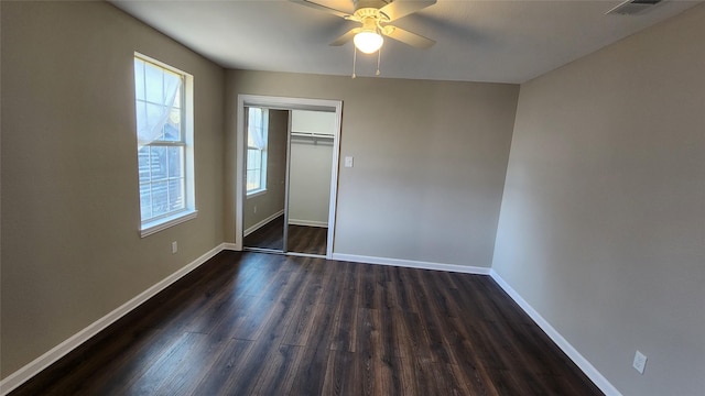 unfurnished bedroom featuring ceiling fan, dark hardwood / wood-style flooring, and a closet