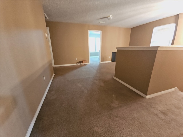 hallway with carpet and a textured ceiling