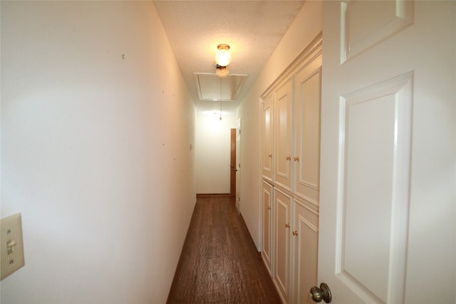 hallway with dark hardwood / wood-style floors and a textured ceiling